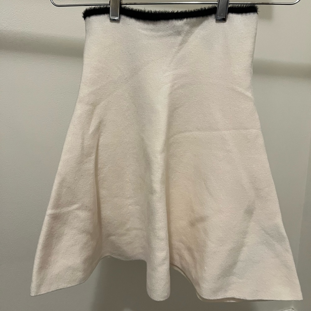 White/creamish with black detailing skirt that flares out and has a fur line